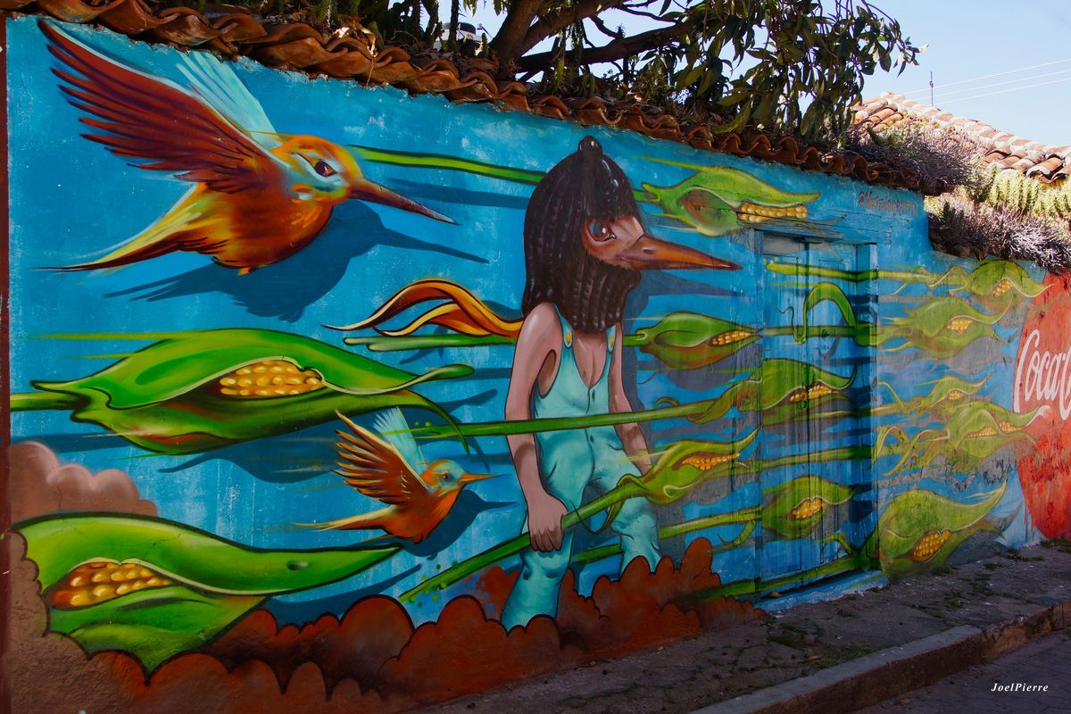 Mur peint en bleu avec un personnage à tête d'oiseau.