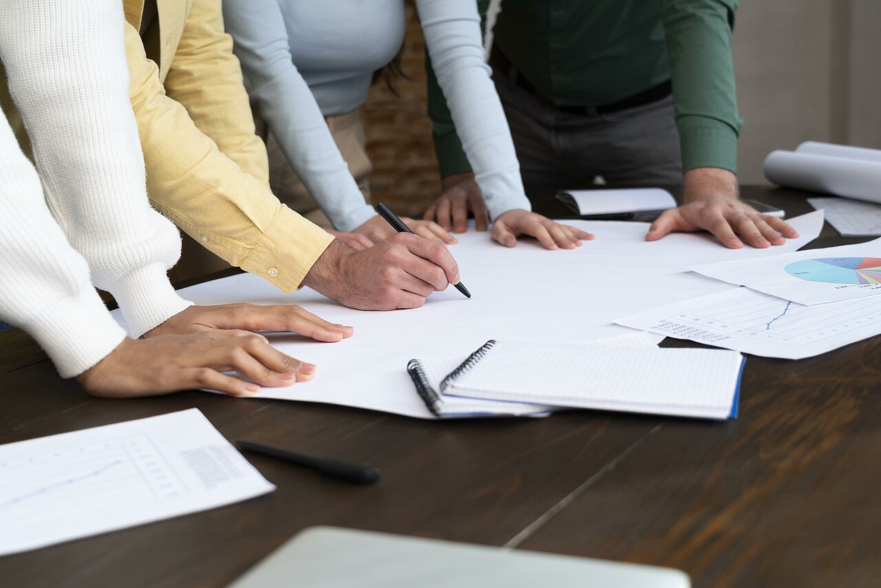 Gros plan sur des bras et des mains sur une table avec des documents